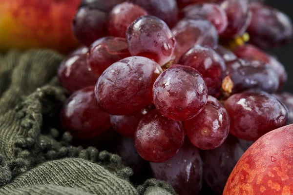 Raisins et pêches sur fond sombre — Photo