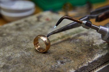 Mücevher üretimi. Kuyumcu altın bir yüzük yapar..