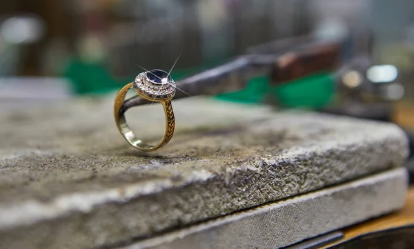 Producción de joyas. El joyero hace un anillo de oro . — Foto de Stock