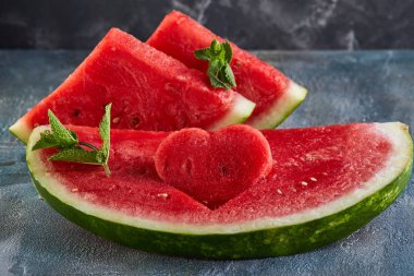 Olgun karpuz, nane yaprakları ve karpuz bir dilim oyulmuş bir kalp ile Kompozisyon. Sevgililer günü için konsept