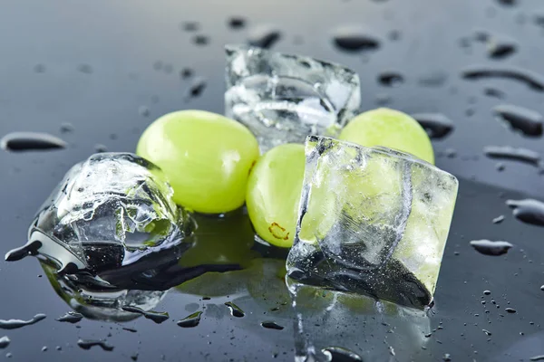 Uvas verdes frescas con gotas de agua y hielo sobre un fondo gris —  Fotos de Stock