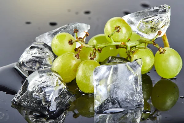 Uvas verdes frescas con gotas de agua y hielo sobre un fondo gris —  Fotos de Stock