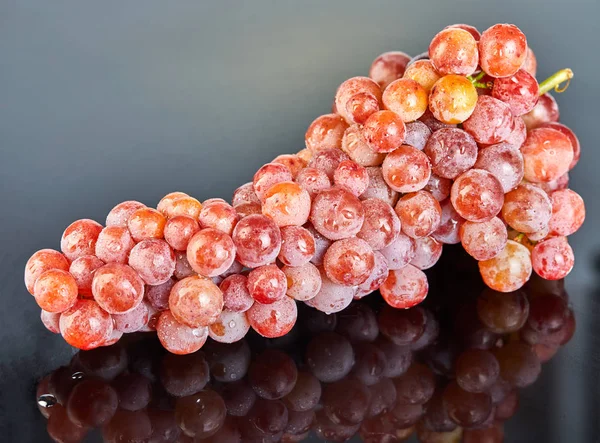 Raisins rouges frais avec des gouttes d'eau sur fond gris — Photo