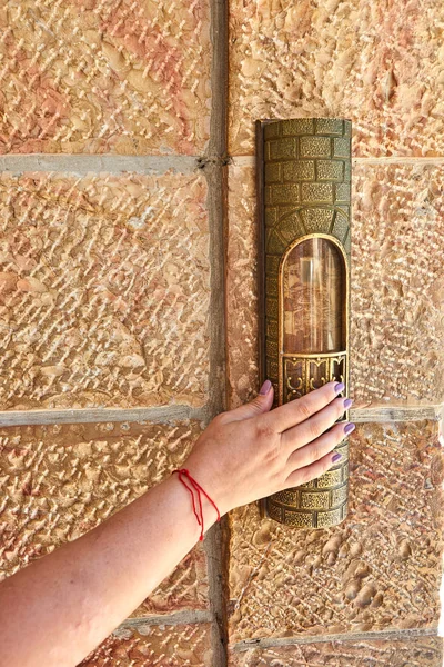 De hand van een vrouw met een rode draad raakt de Mezoeza bij de ingang van het gebied in de buurt van — Stockfoto