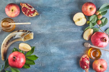 Rosh hashanah - Yahudi Yeni Yıl tatili konsepti. Geleneksel semboller: Bal kavanozu ve narlı taze elmalar ve mavi arka planda shofar boynuzu. Metin için alanı kopyala.
