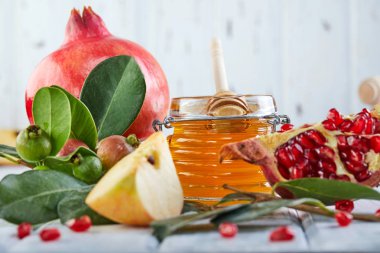 Rosh hashanah - Yahudi Yeni Yıl tatil konsepti. Geleneksel semboller: Bal kavanozu ve beyaz ahşap arka plan üzerinde nar ile taze elma. Kopyalama alanı
