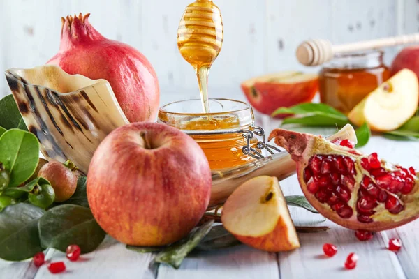 Rosh hashanah - Yahudi Yeni Yıl tatil konsepti. Geleneksel semboller: Bal kavanozve nar ve shofar-beyaz ahşap arka plan üzerinde boynuz ile taze elma. Kopyalama alanı