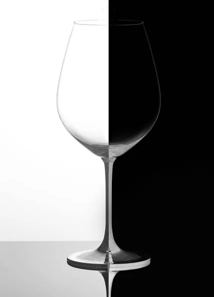 Copa de vino sobre fondo blanco y negro, con reflejo. Concepto de dominó — Foto de Stock