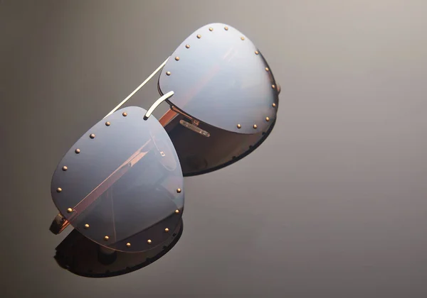 Ženské sluneční brýle na tmavém pozadí s odrazem. Místo pro text — Stock fotografie