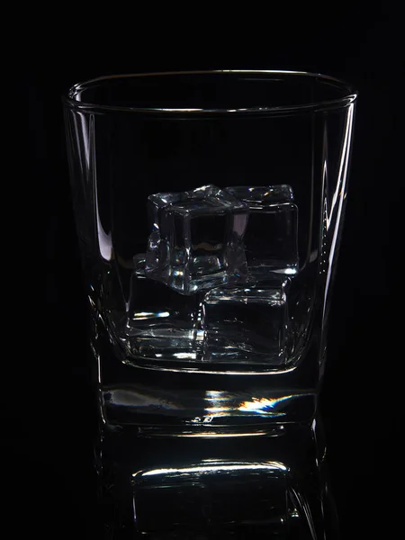 Vaso de whisky con hielo sobre fondo negro con reflejo — Foto de Stock