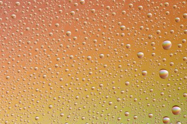 Renkli bir arka plan, doku üzerinde farklı boyut ve renklerde cam damla