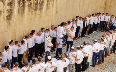 Bir grup dindar insan Tevrat 'ı kutluyor. Şarkı söyle ve Tevrat parşömenlerini tut.