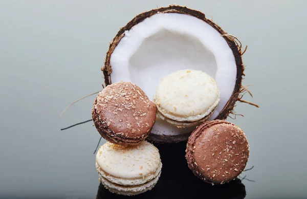 Coco meio fresco com macaroons cho sabor de coco em um fundo cinza com reflexão. Produto biológico vegano — Fotografia de Stock