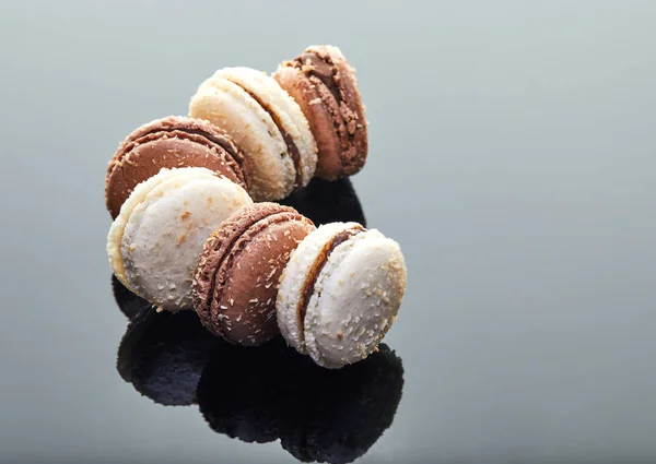 Macaroons com sabor de coco em um fundo cinza com reflexão — Fotografia de Stock