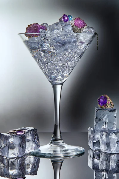反射とグレーの背景に氷と氷のキューブとマティーニグラスでアメジストとブルートパーズとホワイトゴールドジュエリー ジュエリーアート プロダクト販売 — ストック写真