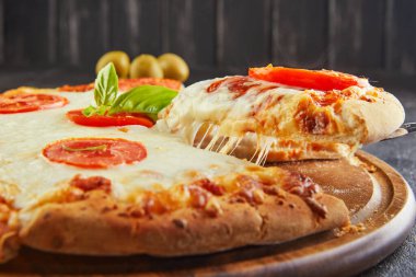 Lezzetli pizza ve mozzarella ve domatesli peynir dilimleri. Peynir ve baharatlı üçgen pizza. Metin için alanı kopyala.