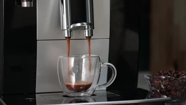 Menuang kopi dari mesin kopi ke dalam cangkir transparan untuk membuat espresso — Stok Video