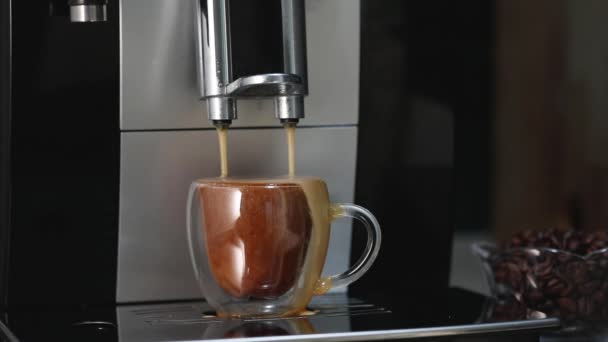 Kahve makinesinden şeffaf bir fincana kahve doldurup espresso yapmak ve kenardan yavaş çekimde kahve dökmek. — Stok video