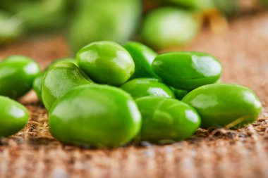 Edamame ya da soya fasulyesi kahverengi bir çuval kumaşa saçılmış..
