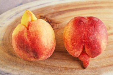 Çirkin bir meyve ya da sebze. Ahşap tezgahta çok çirkin bir şeftali mutantı. Çirkin meyveler çok rağbet görmüyor..