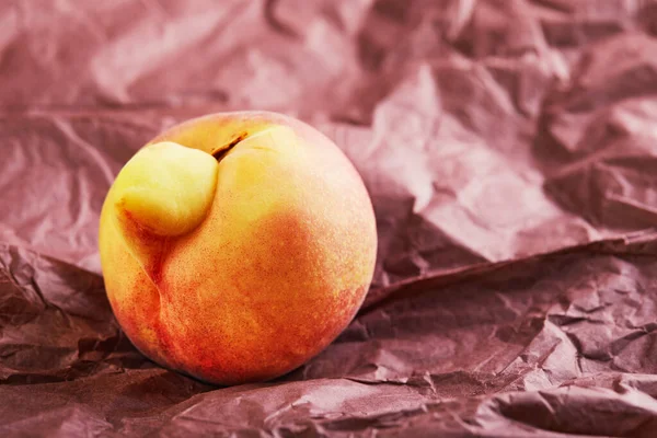Lelijk Fruit Groente Een Lelijke Perzikmutant Paars Papier Lelijke Vruchten — Stockfoto