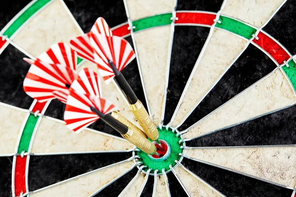 Success hitting target aim goal achievement concept background - three darts in bull\'s eye close up. red three darts arrows in the target center business goal concept