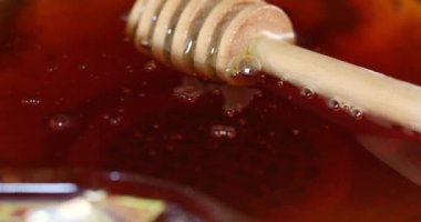 Elma şeklinde bir bal kasesi ve beyaz bir stantta dönen tahta bir sopa, Rosh hashanah Yahudi Yeni Yıl konsepti..