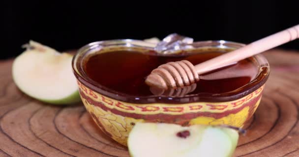 Ahşap tezgahta bir elmayı bala batırır, Rosh hashanah - Yahudi Yeni Yıl konsepti. — Stok video