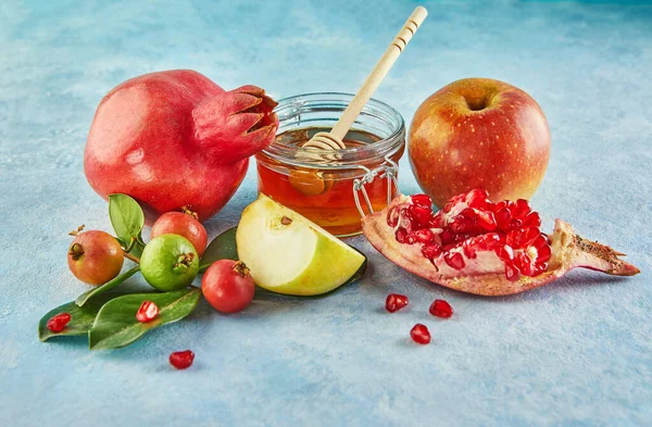 Rosh Hashanah, Yahudi Yeni Yıl tatili için bir kavramdır. Mavi arka planda elma ve nar yaprakları şeklinde bir kasede sopa olan biftek balı..