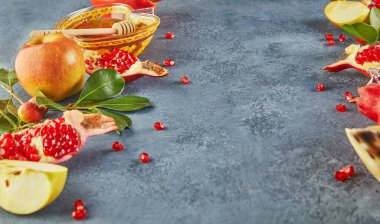 Rosh hashanah - Yahudi Yeni Yıl tatili konsepti. Geleneksel semboller: Bal kavanozu ve narlı taze elmalar ve mavi arka planda shofar boynuzu. Metin için alanı kopyala.