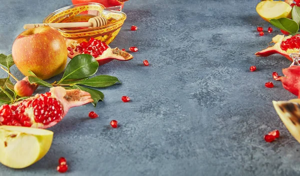 Rosh hashanah - Yahudi Yeni Yıl tatili konsepti. Geleneksel semboller: Bal kavanozu ve narlı taze elmalar ve mavi arka planda shofar boynuzu. Metin için alanı kopyala.