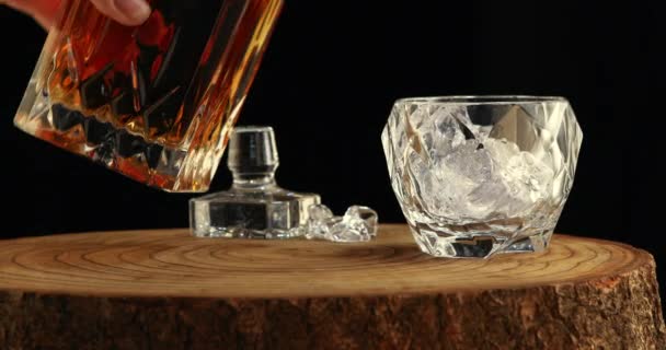 Pouring whiskey into a glass with ice — Stock Video