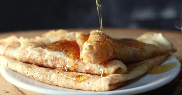 나무 막대기에서 나오는 꿀 이 팬케이크 접시에 떨어지다 — 비디오
