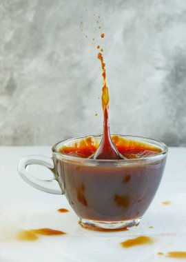 Gri-beyaz arka planda bir bardakta bir bardak kahve..