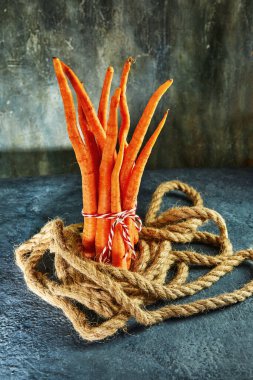 Çirkin yemek. Mavi zemin üzerinde deforme olmuş organik havuçlar. Bozulmuş ürünler, gıda atığı konsepti.