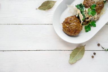 Et pirzolaları beyaz bir tabakta yüksek mutfağa yakın planda.