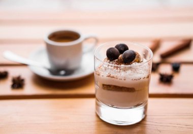 Bulanık bir arka planda bardakta tiramisu. Kafe masası.