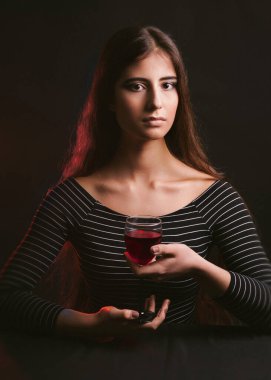 Siyah arka planda doğal makyajlı, şarap kadehli bir kız.