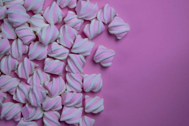 Bir sürü marshmallow pembe bir backgro üzerinde yan serilir