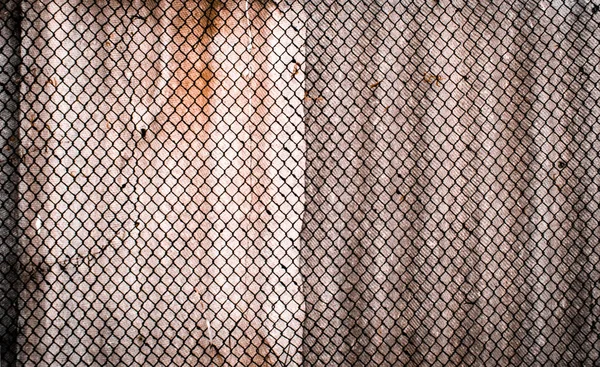 Wallpaper of old rusty metal grid, against a background of a con — Stock Photo, Image