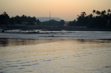 Güneşin doğuşunu deniz, dağ ve ağaçlar