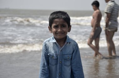 Mumbai yakınlarındaki Alibaug plajda oynayan çocuk.