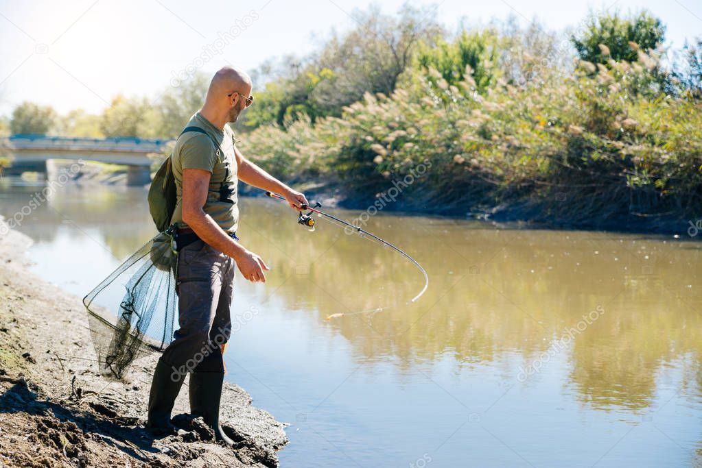 Spin fishing on a river with rod