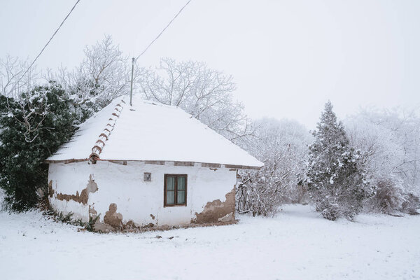 Old house on winter snowy field