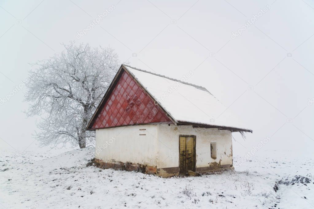 Old house on winter snowy field