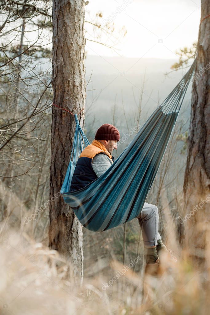 Young man resting in hammock, outdoor lifestyle