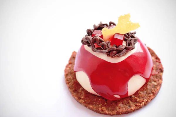 Red and white dessert with chocolate decoration, red jelly and cookie base — Stock Photo, Image