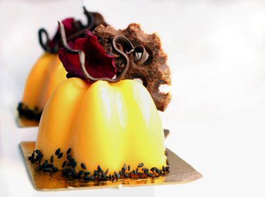 Gül yaprağı ve beyaz zemin üzerine çikolata dekor turuncu kek