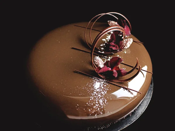 Čokoládový dort s lesklé zrcadlo glazurou a květinové lístky — Stock fotografie