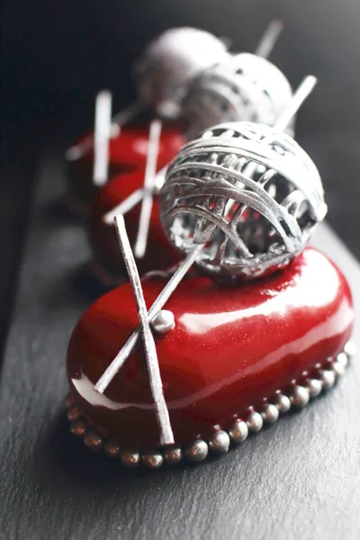 Red chocolate berry dessert with silver wool ball decoration and mirror glaze